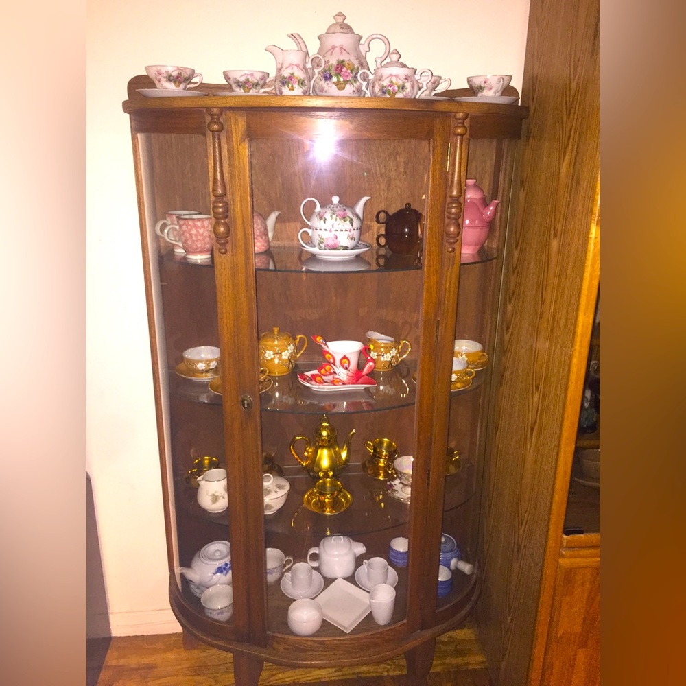 Wood and glass curio approx 5.5’ tall 4’ wide glass shelves inside light.